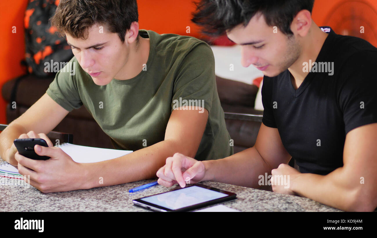 Les jeunes étudiants qui étudient avec des gadgets Banque D'Images