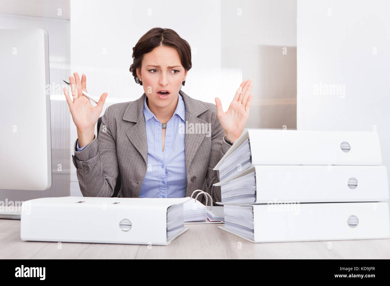 Portrait of a souligné businesswoman looking at pile de dossiers Banque D'Images
