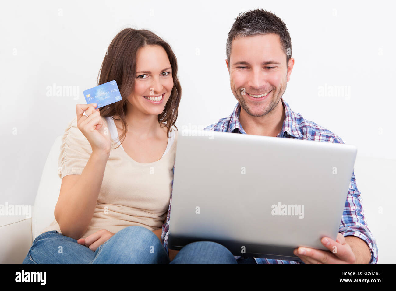 Portrait Of A Happy Young Couple Shopping Online With Credit Card Banque D'Images