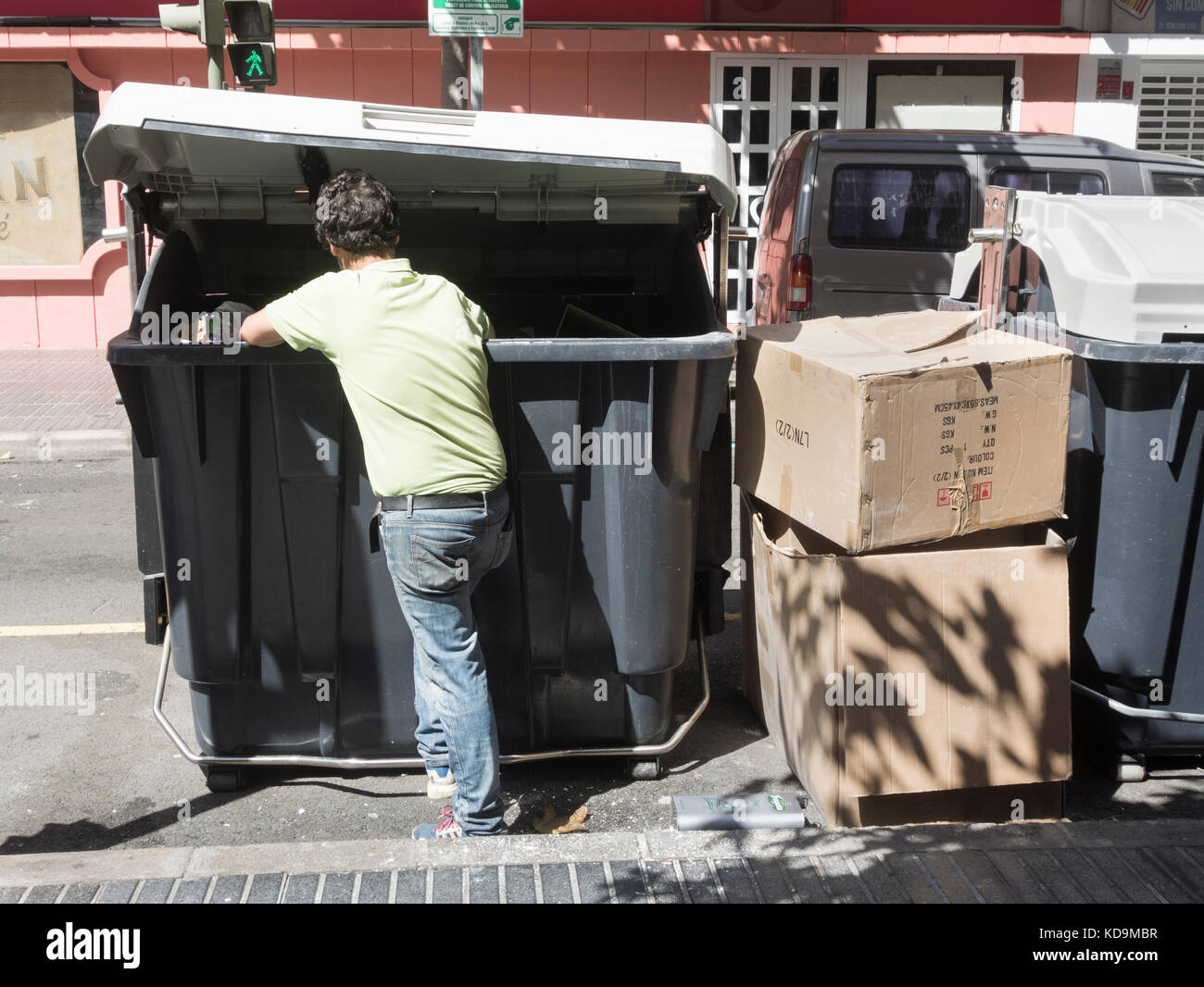 L'homme à la recherche de nourriture dans les poubelles dans la rue en Espagne Banque D'Images
