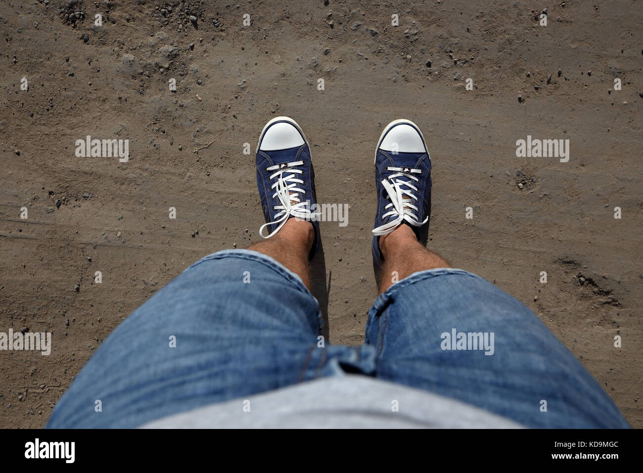 Point de vue d'un homme tourné vers le bas pour regarder ses pieds standing on country road. Banque D'Images Point de vue d'un homme tourné vers le bas pour regarder ses pieds standing on country road. Banque D'Images