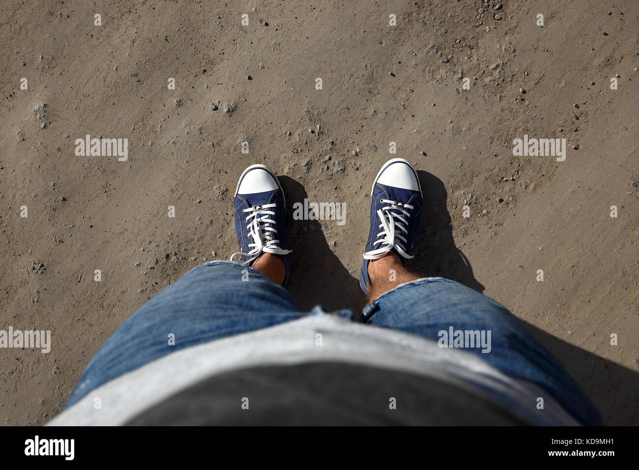 Point de vue d'un homme tourné vers le bas pour regarder ses pieds standing on country road. Banque D'Images Point de vue d'un homme tourné vers le bas pour regarder ses pieds standing on country road. Banque D'Images