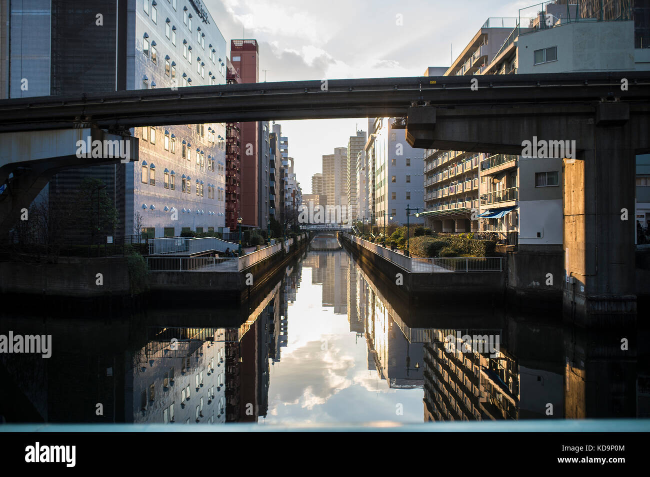 Magnifique coucher de soleil derrière les toits de Tokyo avec des bâtiments reflètent dans la rivière. Banque D'Images