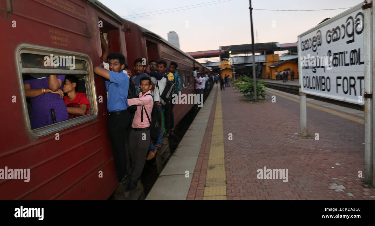 Colombo, Sri Lanka. 12 octobre, 2017. Les passagers du Sri Lanka sur les poignées de porte à tenir pendant qu'ils voyagent dans un wagon d'un train pendant une grève des chemins de fer à Colombo le 12 octobre 2017. Former des ingénieurs et des conducteurs ont organisé la grève pour exiger un salaire plus élevé. crédit : lahiru harshana/Alamy live news Banque D'Images