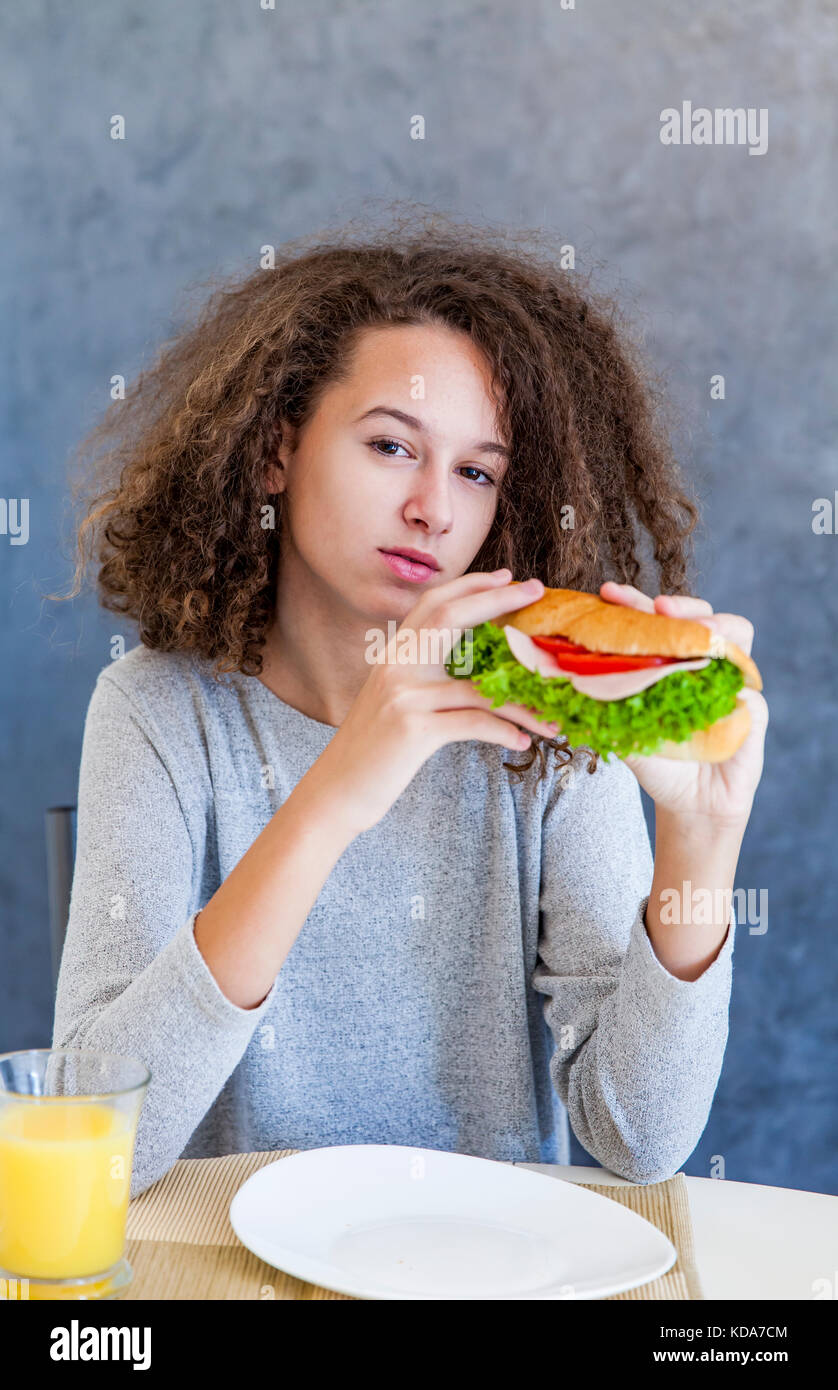 Portrait de cheveux bouclés teen girl le petit-déjeuner à l'accueil Banque D'Images