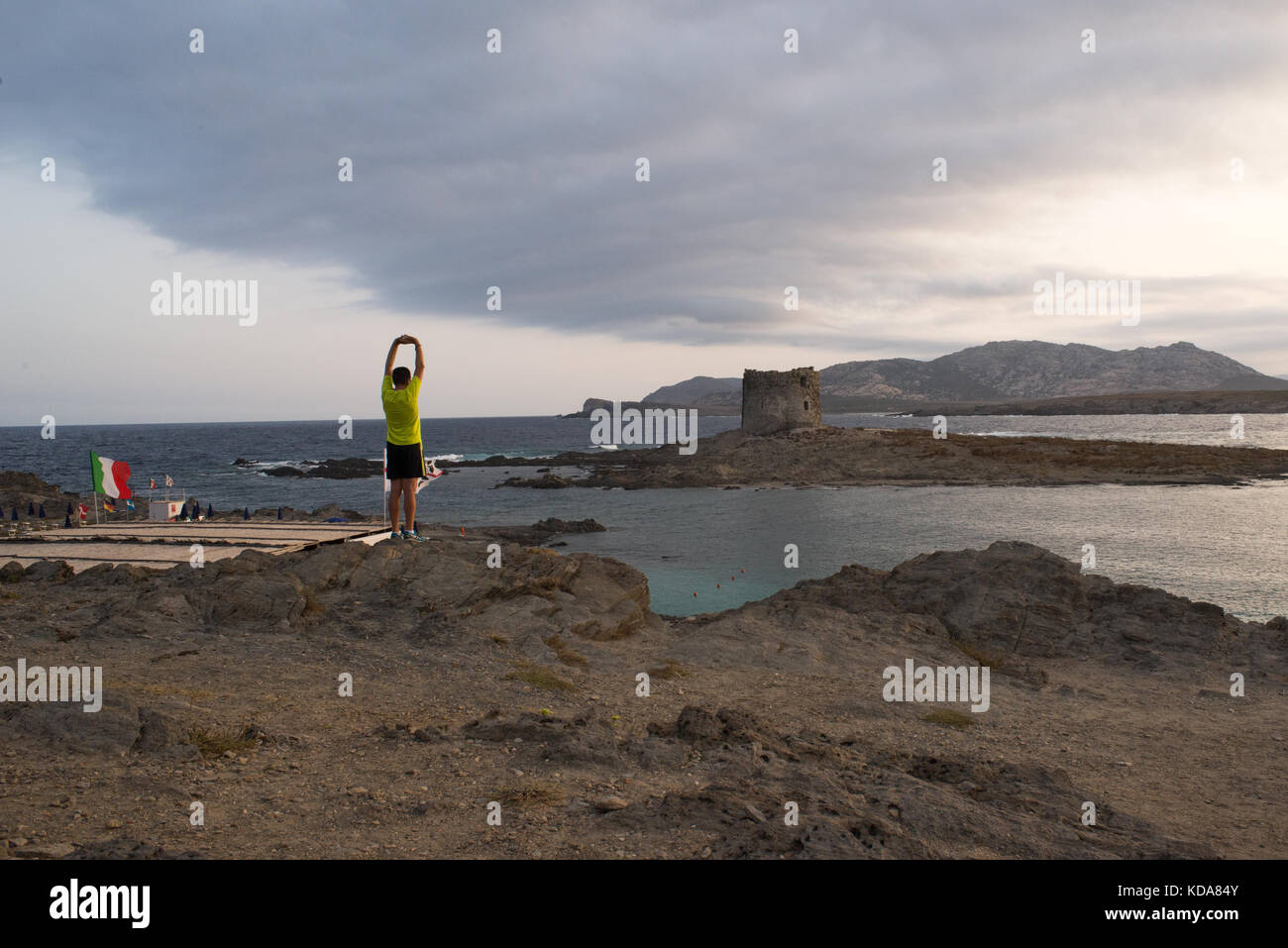 Un homme de faire du sport à l'aube en face d'un merveilleux paysage à plage de la pelosa en Sardaigne, Italie Banque D'Images