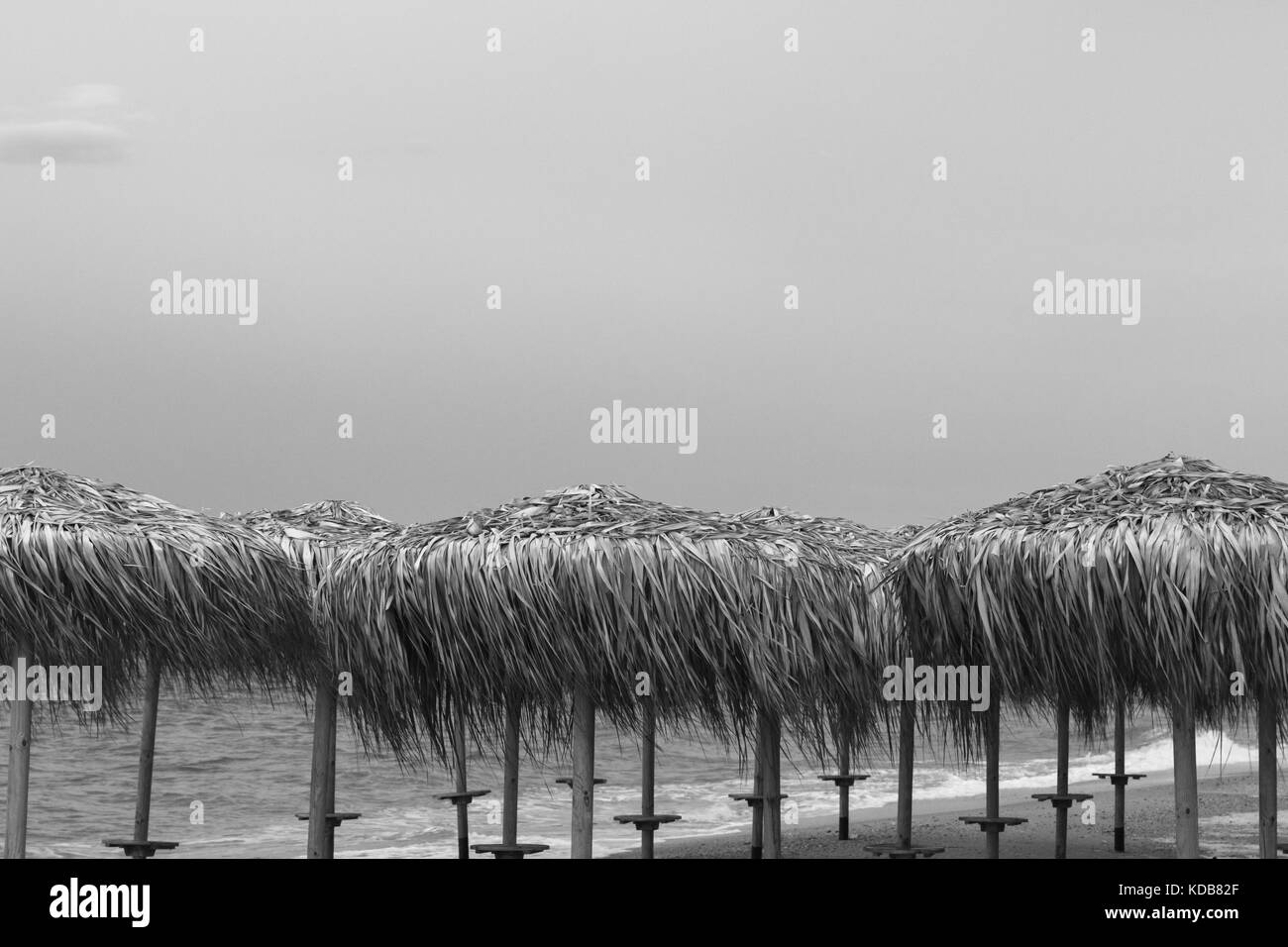 Rencontre avec un nouveau jour à l'aube sur le rivage d'une mer calme dans le sable sous les parasols seul avec une vue sur le ciel Banque D'Images