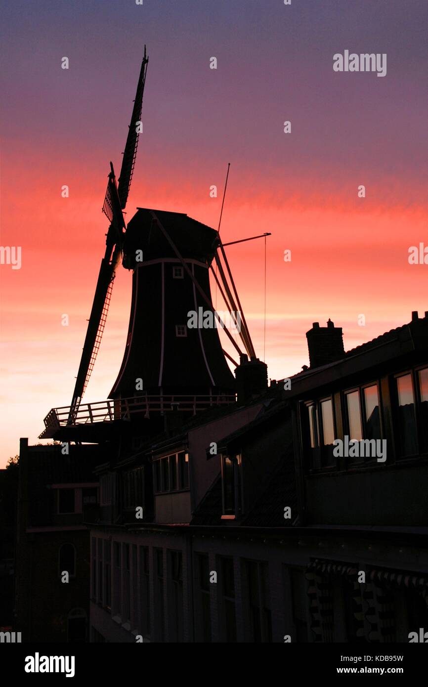 Moulin à vent hollandais, de adriaan, vu en silhouette contre un coucher de soleil spectaculaire à Haarlem, aux Pays-Bas. Banque D'Images