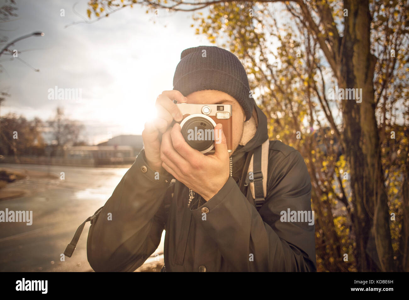 Jeune homme de prendre une photo avec appareil photo instantané Banque D'Images