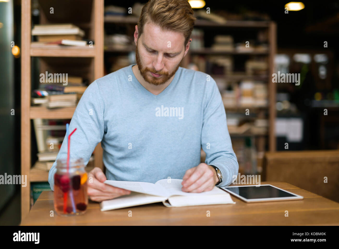 Young handsome student learning in coffee shop Banque D'Images