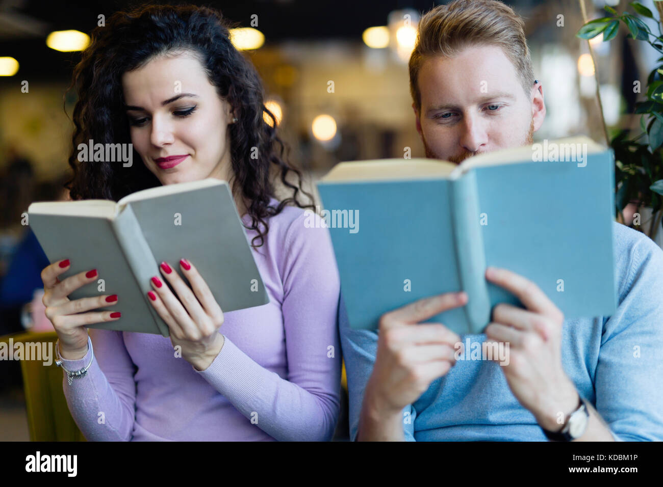 De jeunes étudiants de passer du temps dans la lecture de livres café Banque D'Images