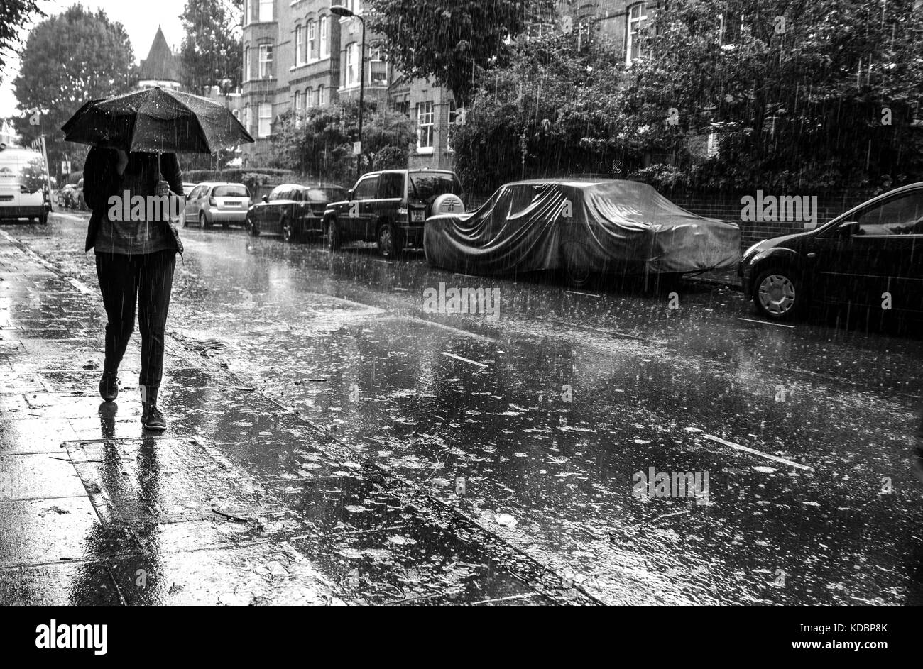 Femme avec parapluie pluie torrentielle Banque D'Images