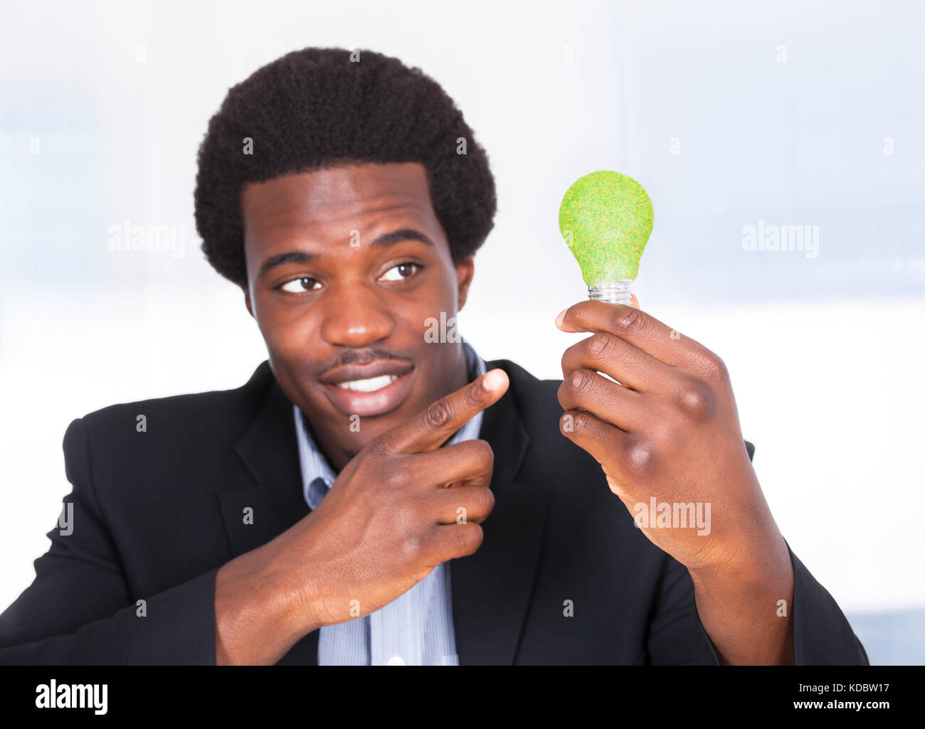 Happy Young Woman Holding ampoule avec de l'herbe verte Banque D'Images