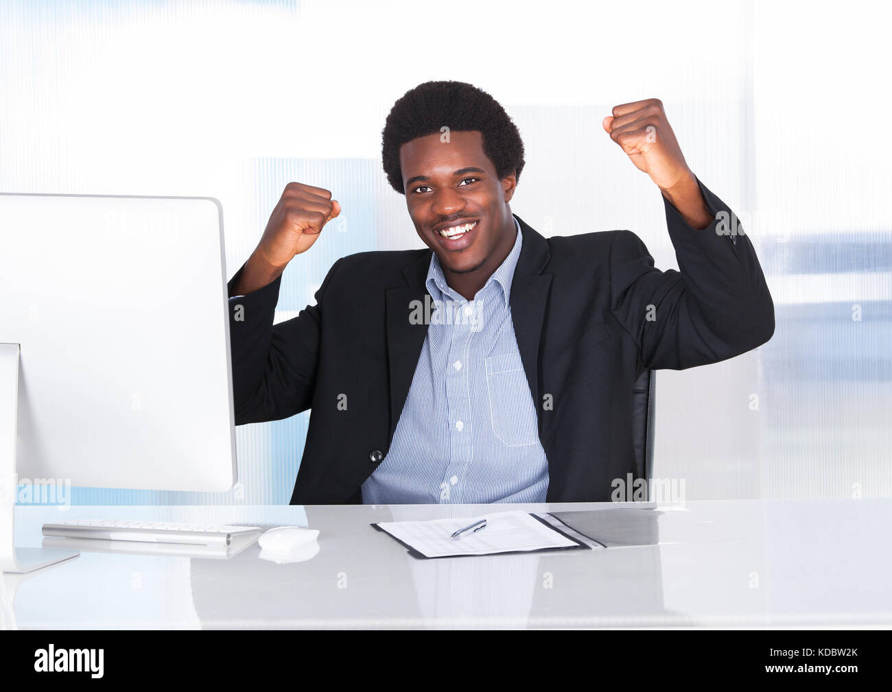 Portrait Of A Happy heureux homme africain assis en face de Desktop Banque D'Images