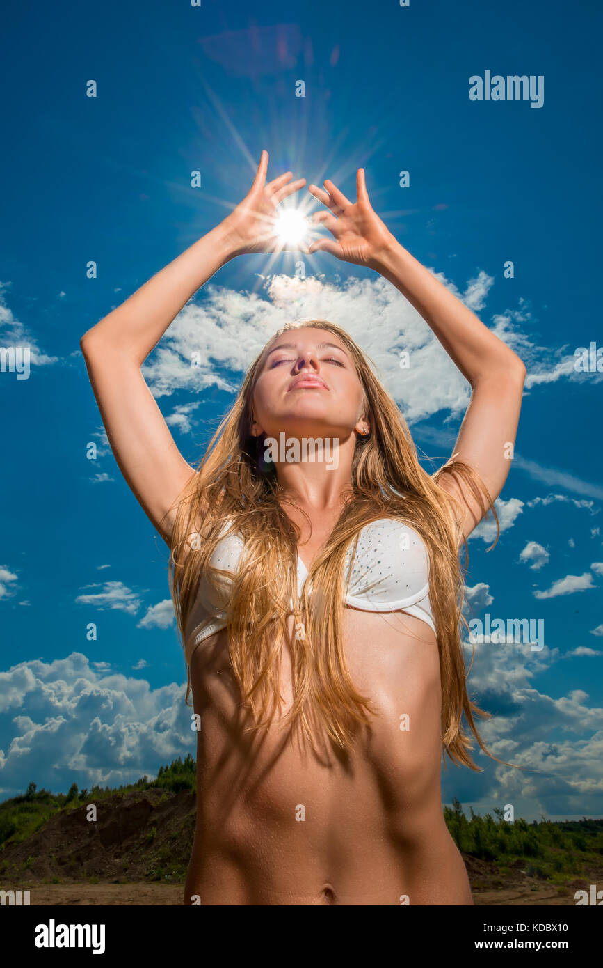 Portrait vertical d'un modèle mince avec le soleil dans ses mains Banque D'Images