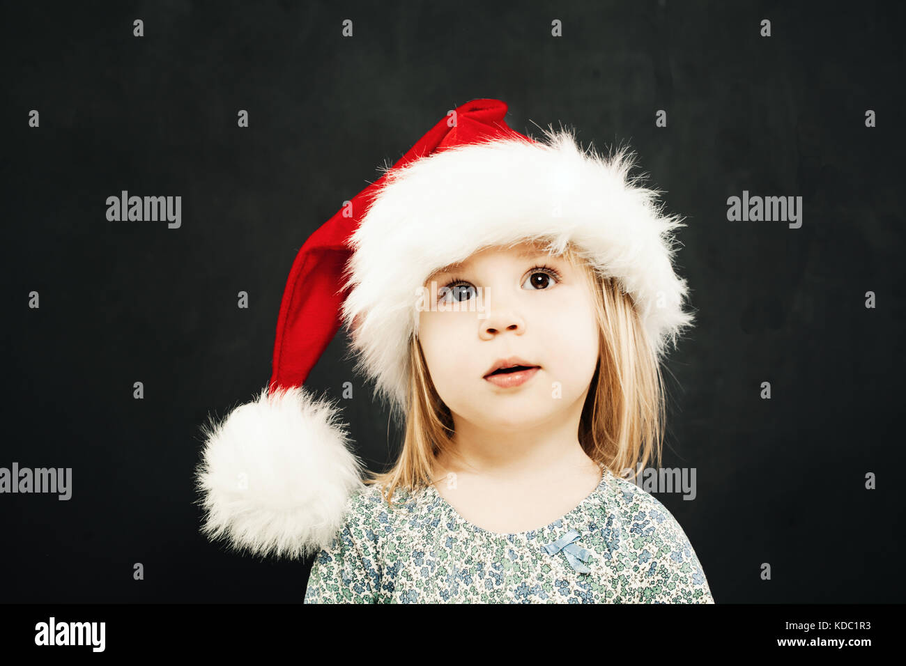 Noël des enfants girl in santa hat rêver sur fond noir Banque D'Images