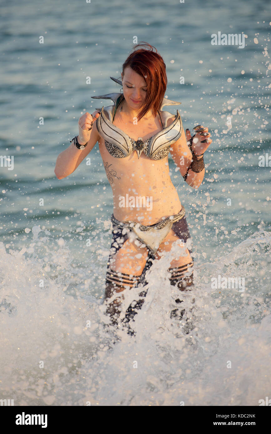 Jeune fille dans un costume cosplay de style bikini à la plage au coucher  du soleil Photo Stock - Alamy