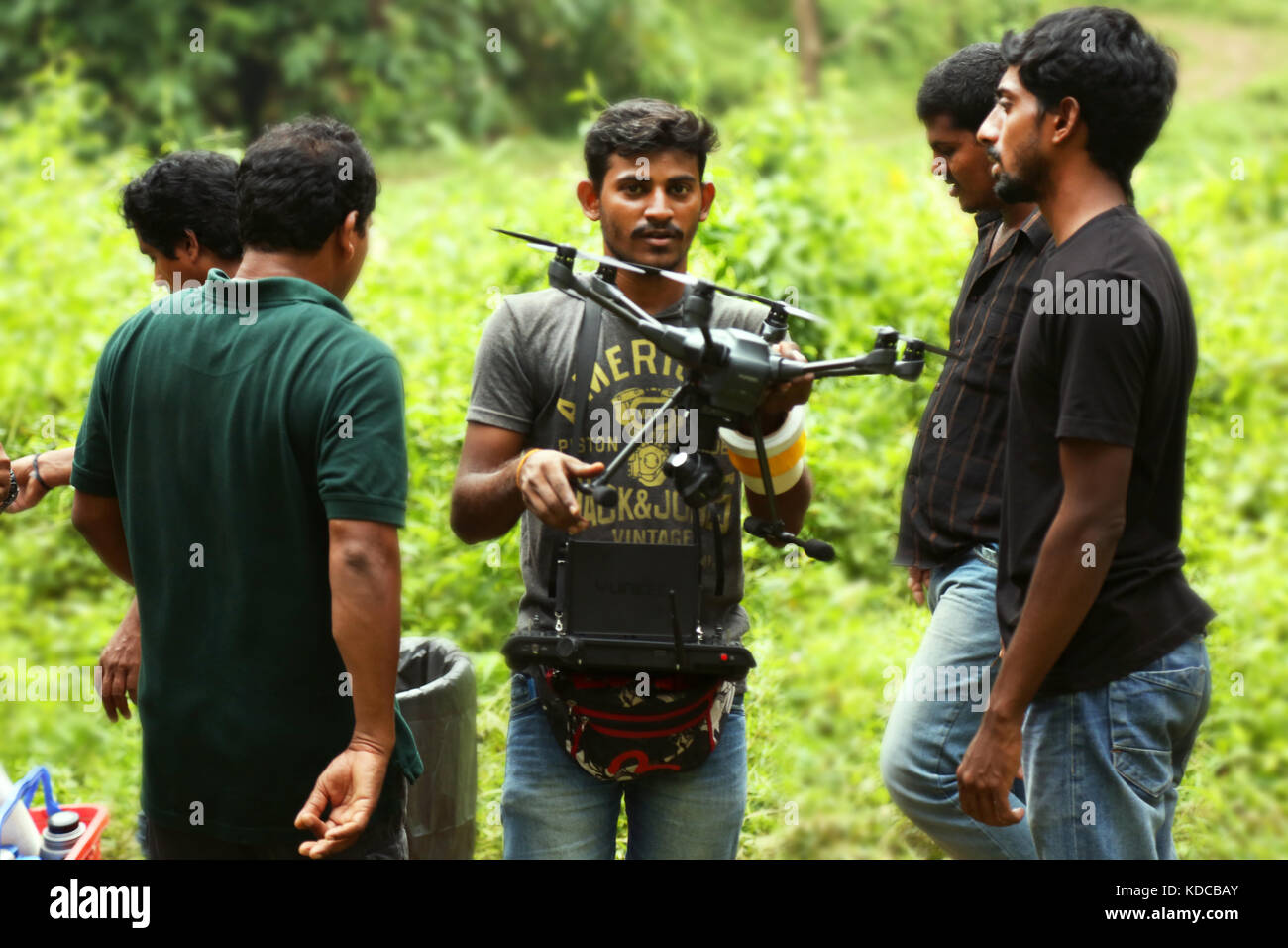 Jeune homme avec deux aidé photographe est de réaliser une vidéo avec radio controlled quadcopter, Banque D'Images