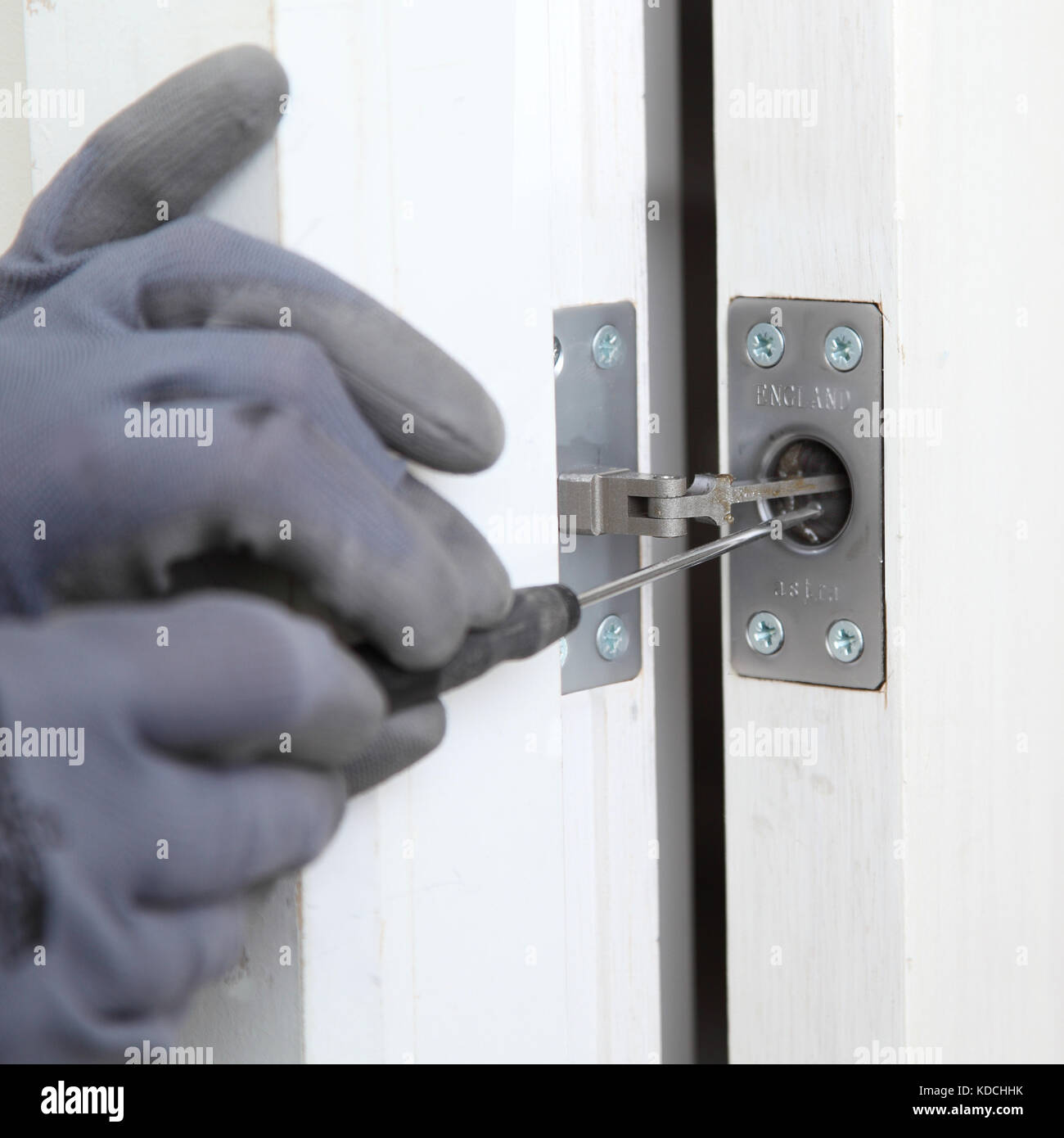 Un ouvrier installe un près dissimulé d'une nouvelle porte d'incendie dans le cadre de la rénovation d'un immeuble résidentiel à Londres, au Royaume-Uni. Banque D'Images