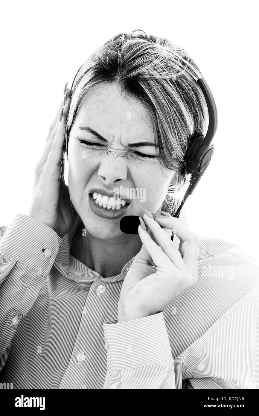 Frustré a souligné femme parlant à un client à l'aide d'un casque téléphonique serrant ses dents en colère avec elle les yeux fermés Banque D'Images