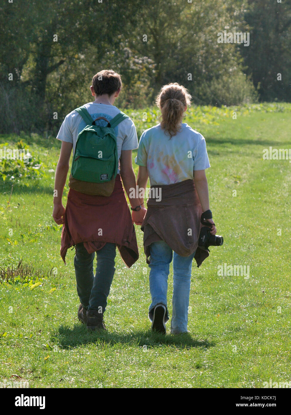 Young adult couple walking and holding hands, uk Banque D'Images