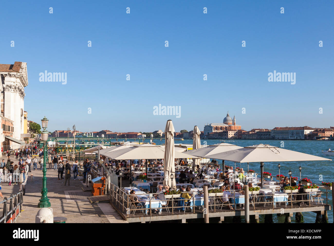 Zattere, Dorsoduro, Venise, Italie. Les touristes assis à l'air ouvert restaurants manger au coucher du soleil avec vue sur le canal Giudecca Banque D'Images