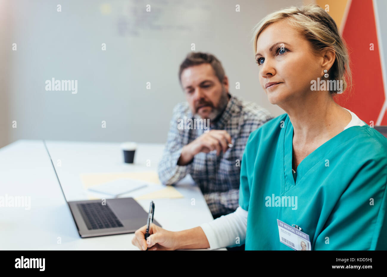 Femelle adulte professionnel médical en réunion avec le personnel de l'hôpital. Médecin assis à la salle de conférence au cours de réunion. Banque D'Images
