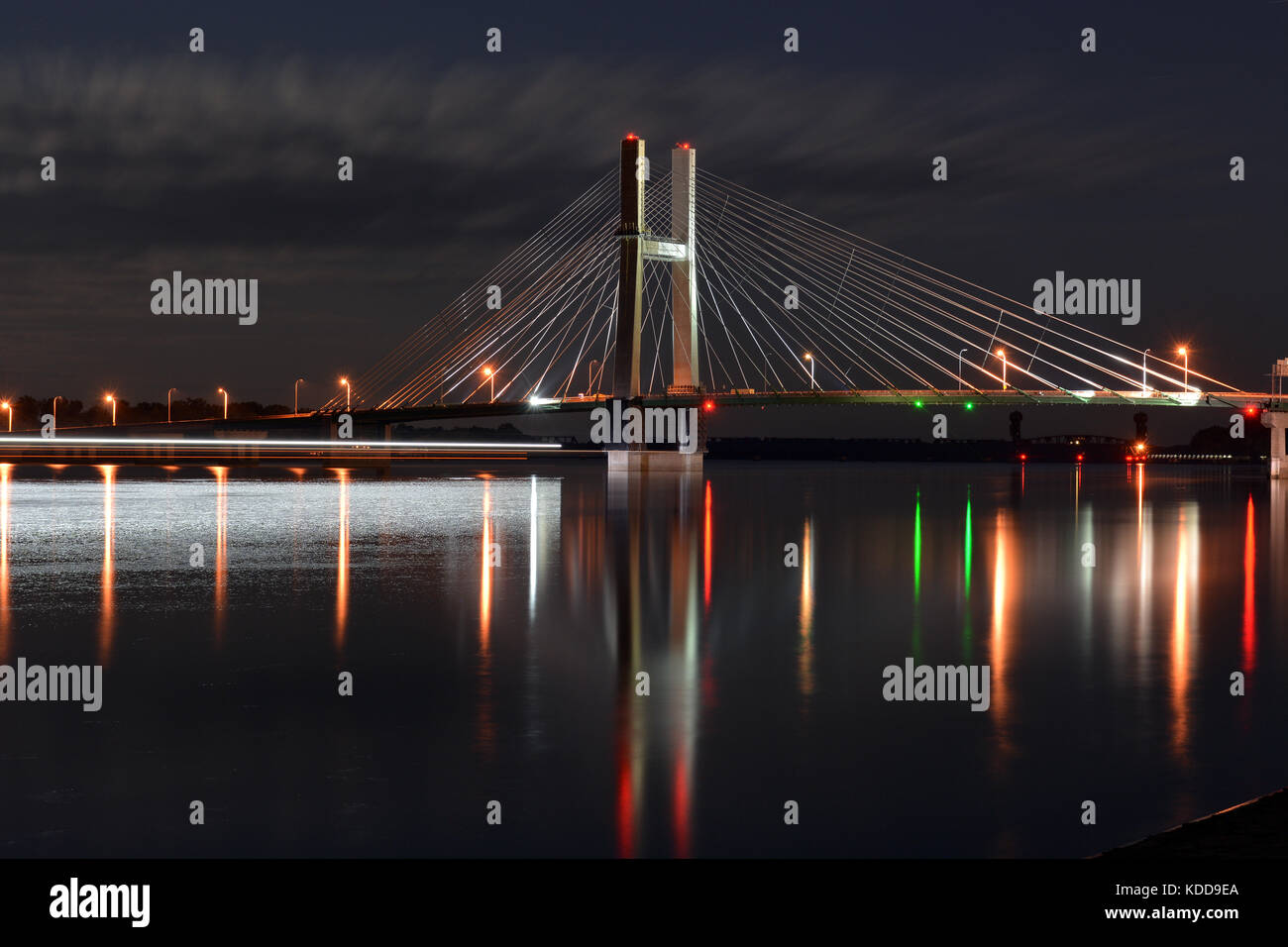 Les Sentiers de la lumière d'une barge flottait vers le grand pont sur la rivière Mississippi River Banque D'Images