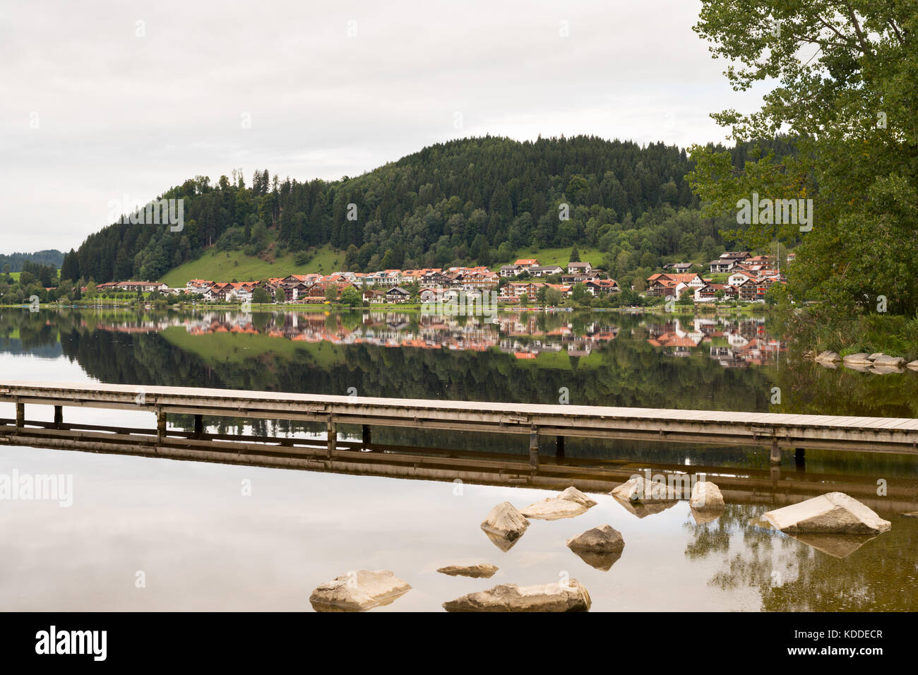 La ville de Hopfen am See reflète dans l'eau de l'Hopfensee, Ostallgaeu, Bavière, Allemagne Banque D'Images