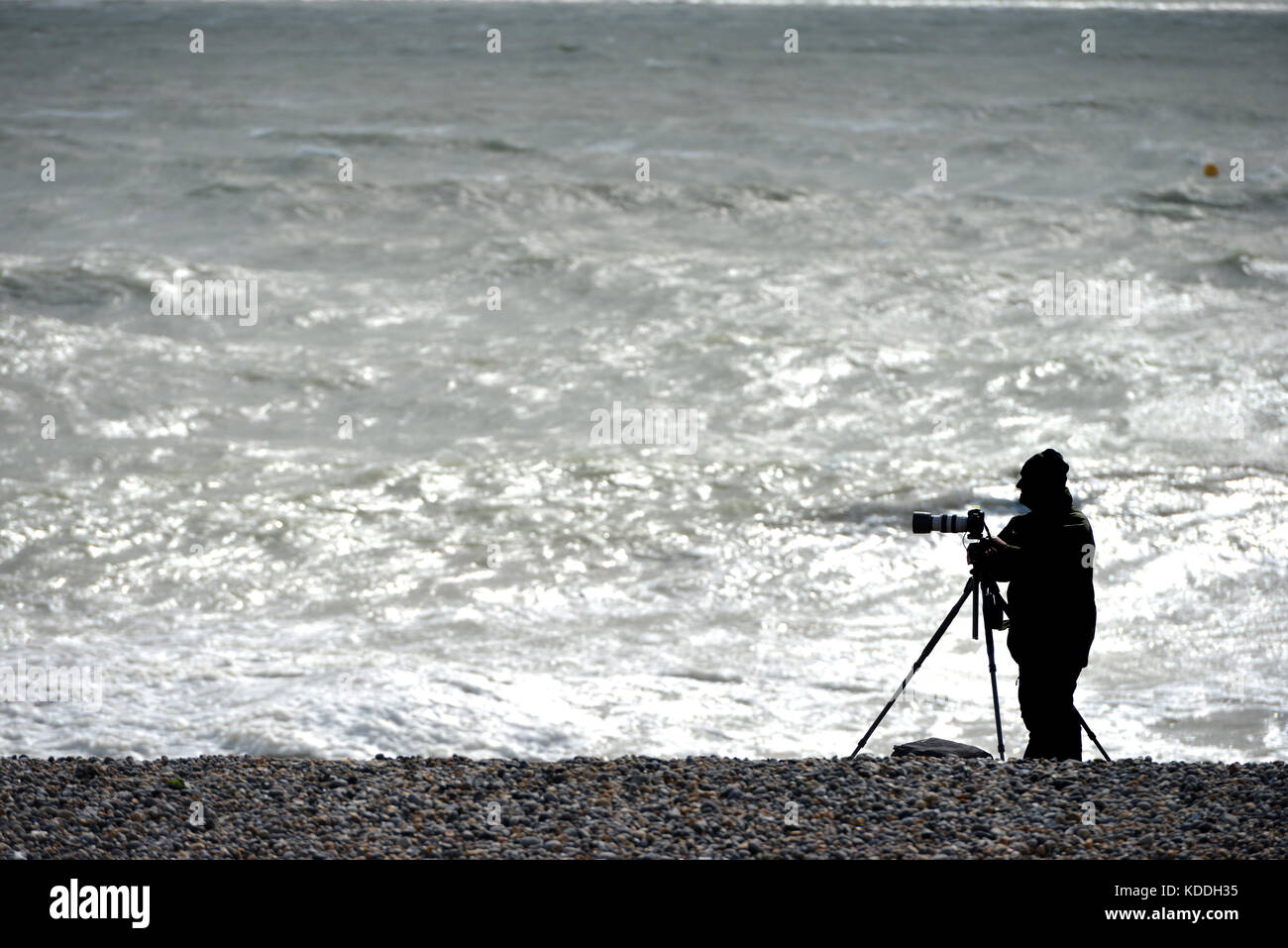 Photographe sur une plage en hiver, silhouette non identifiables. Banque D'Images
