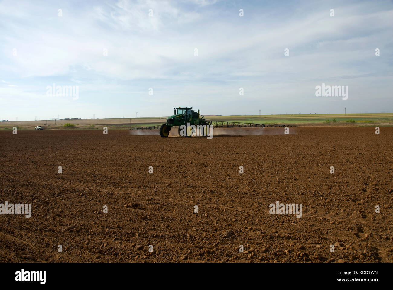 Tracteur John Deere de pulvériser le sol labouré avec herbicide pré-émergence Banque D'Images