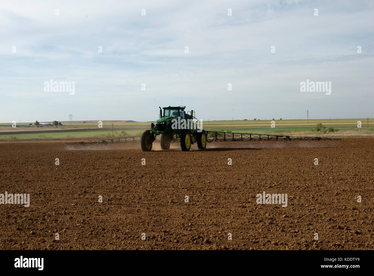 Tracteur John Deere de pulvériser le sol labouré avec herbicide pré-émergence Banque D'Images