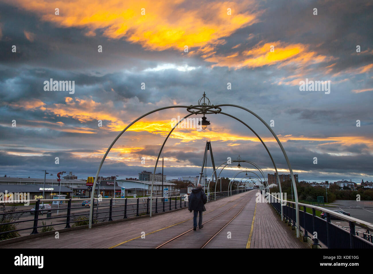 Southport, Merseyside, Royaume-Uni. 13 octobre, 2017. Lever du soleil sur l'resort pier avec une formation de nuages bas fractostratus stimulé par une forte pluie vent sous-nuages. Un ciel rouge à l'aube d'un jour de vent turbulent herald ferma comme de grands vents, des nuages de précéder par une prévision de fortes averses et pluie persistante. Des travaux sont maintenant en cours sur les £2.9Million projet visant à transformer la jetée de Southport qui verra une combinaison de travaux de réfection et d'améliorations, y compris les nouvelles unités de vente au détail et des escaliers supplémentaires et à la plage. Crédit. MediaWorldImages/Alamy Live News. Banque D'Images