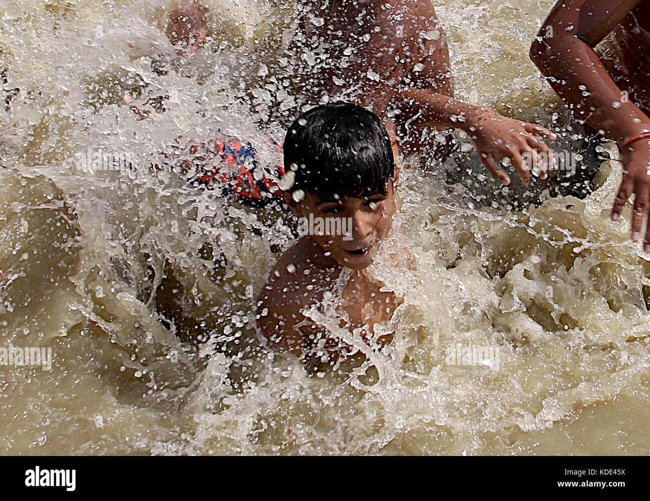 Karachi. 13 octobre 2017. Les garçons pakistanais se rafraîchissent dans un canal d'eau alors que la température atteignait 42 degrés Celsius dans le sud du port pakistanais de Karachi le 13 octobre 2017. Crédit : Arshad/Xinhua/Alamy Live News Banque D'Images