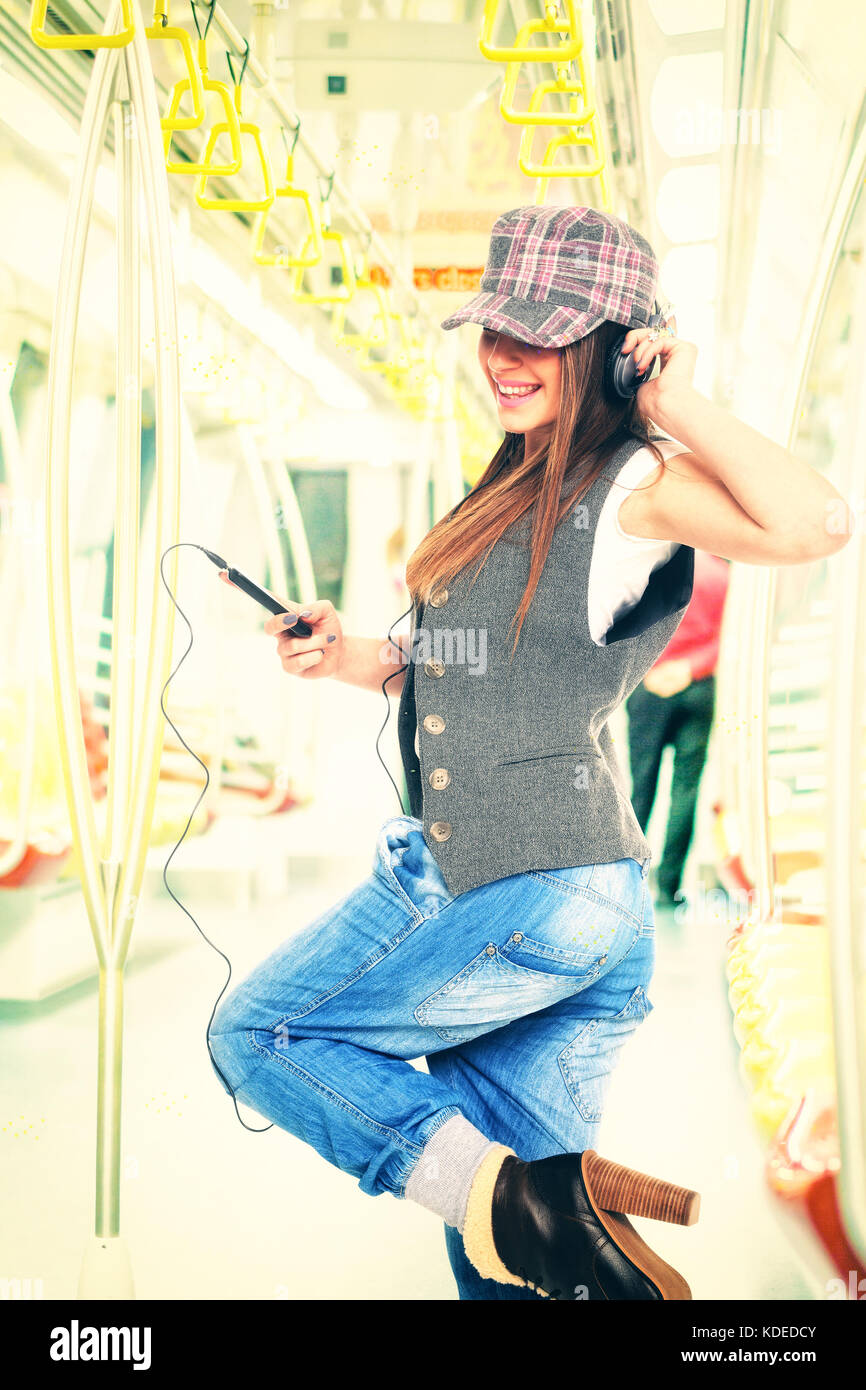 Femme dans le métro écoutant de la musique dans son casque Banque D'Images