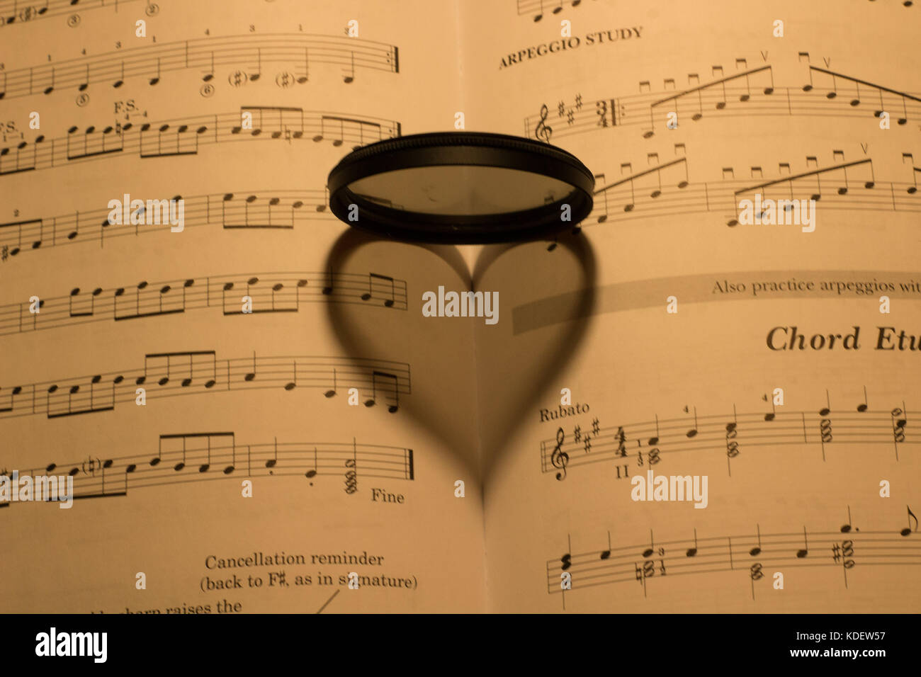 L'ombre en forme de coeur sur une musique vintage feuille sous la lumière d'une lampe Banque D'Images
