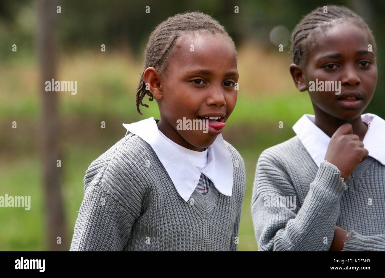 Deux filles de l'école de l'Afrique de faire des grimaces et de rire dans la cour de l'école Banque D'Images