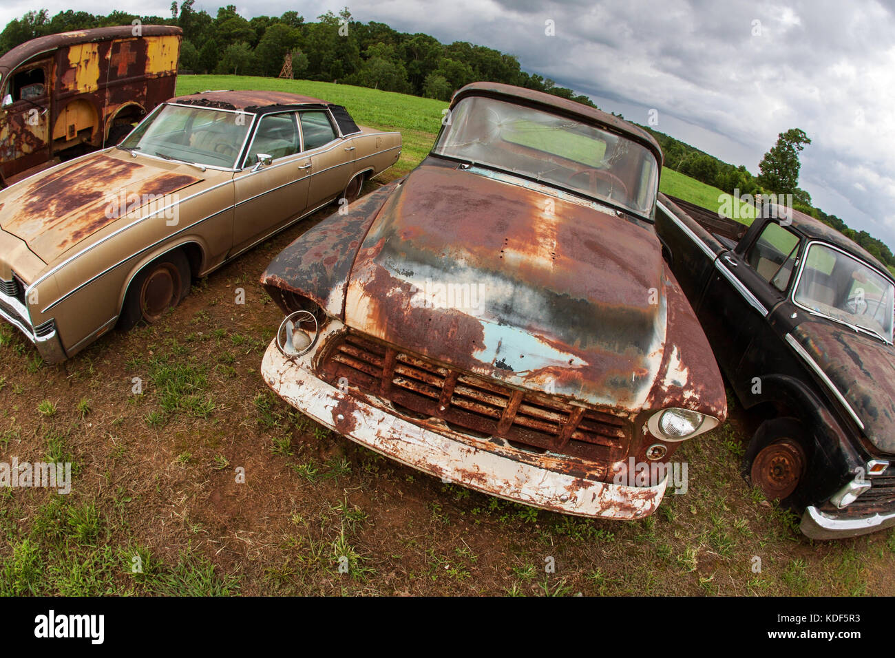 Des véhicules anciens rouillé assis alignés dans une casse auto Photo Stock  - Alamy