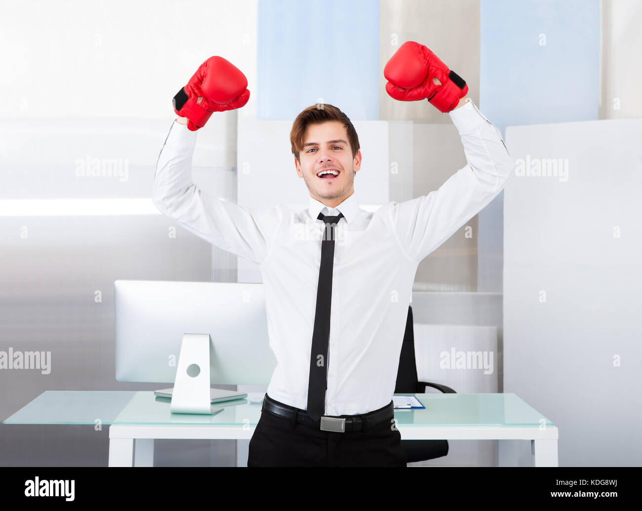 Portrait d'un homme d'affaires prospère wearing red boxing gloves in office Banque D'Images