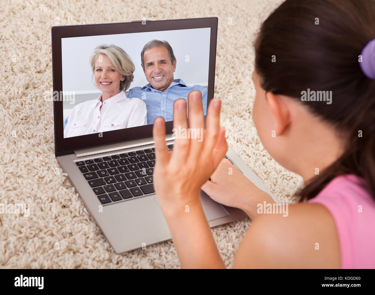 Jeune femme ayant une conversation vidéo avec happy parents Banque D'Images
