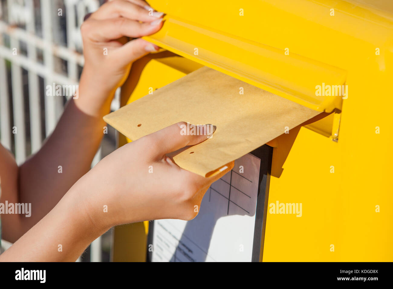 Close-up of woman's hand inserting enveloppe dans la boîte aux lettres Banque D'Images