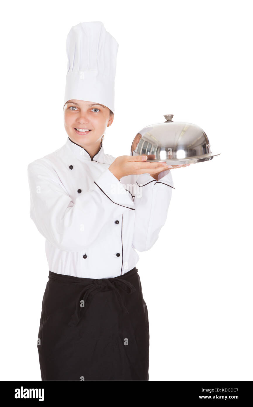 Portrait of female chef holding plateau sur fond blanc Banque D'Images