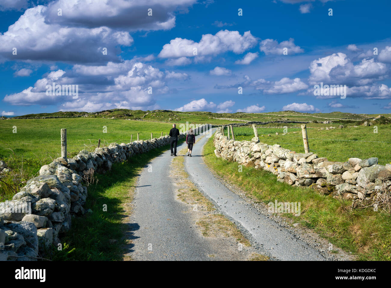 Couple walking on road sur omey island. connemara comté de Galway, Irlande, Banque D'Images