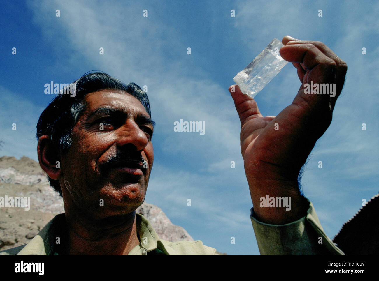 Un travailleur de la mine de sel Kalabach détient un morceau de sel gemme transparente entre les mines, près de Kalabach, au Pakistan. Banque D'Images