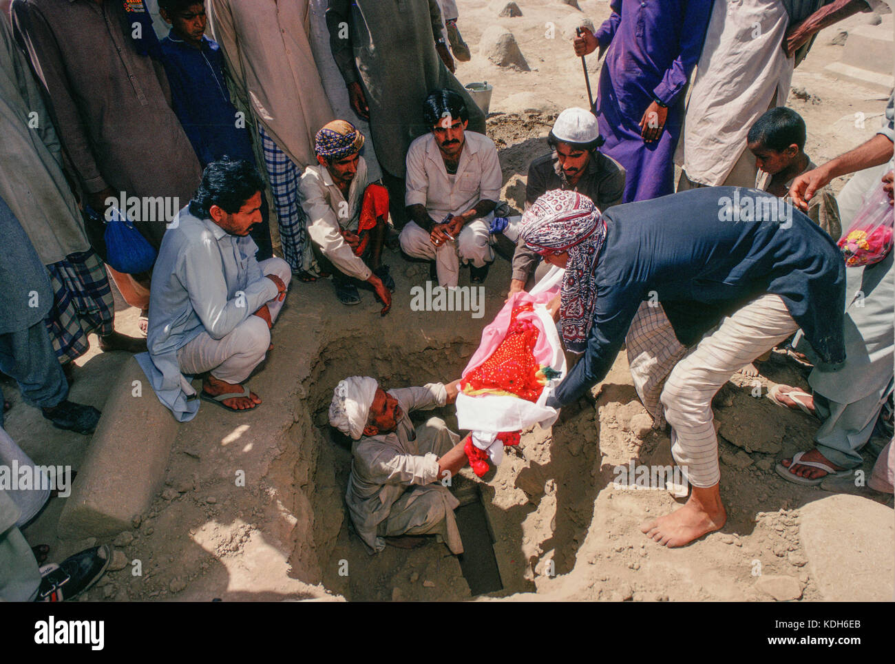 Un homme enterre le corps de son fils sur la tombe de Bibi à Jawindi UCH. Banque D'Images