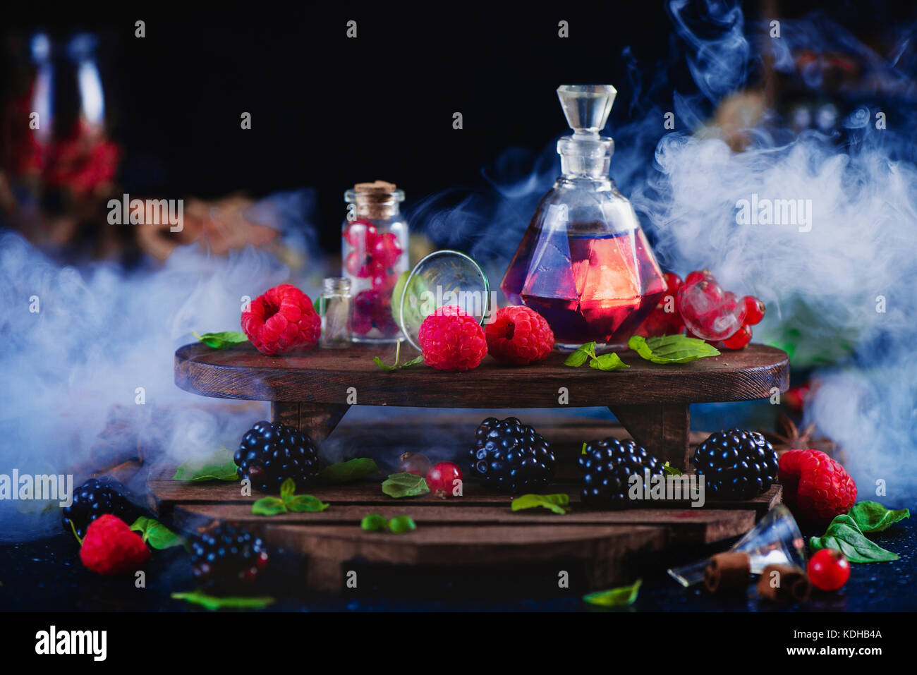 Parfum framboise et blackberry dans un flacon vintage. dark vie encore avec wintage étagères en bois et de baies fraîches laboratoire aromatiques. concept, magi Banque D'Images