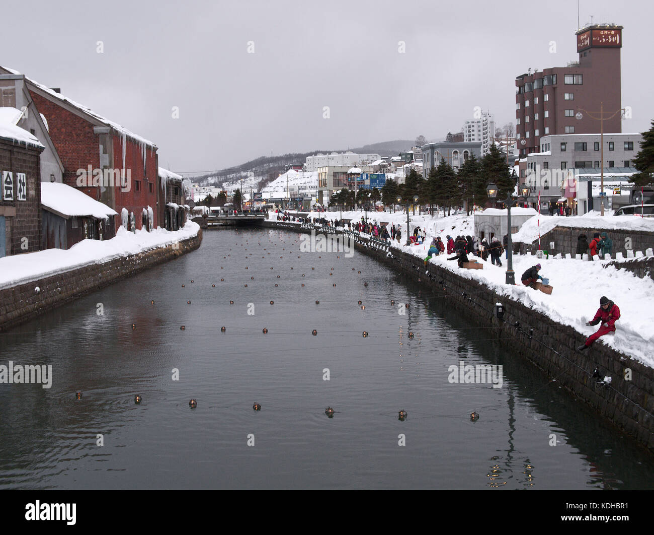 Les travailleurs préparant des lanternes pour l'événement de lumière d'hiver d'Otaru et les touristes appréciant la scène à Otaru Canel, Hokkaido, Japon Banque D'Images