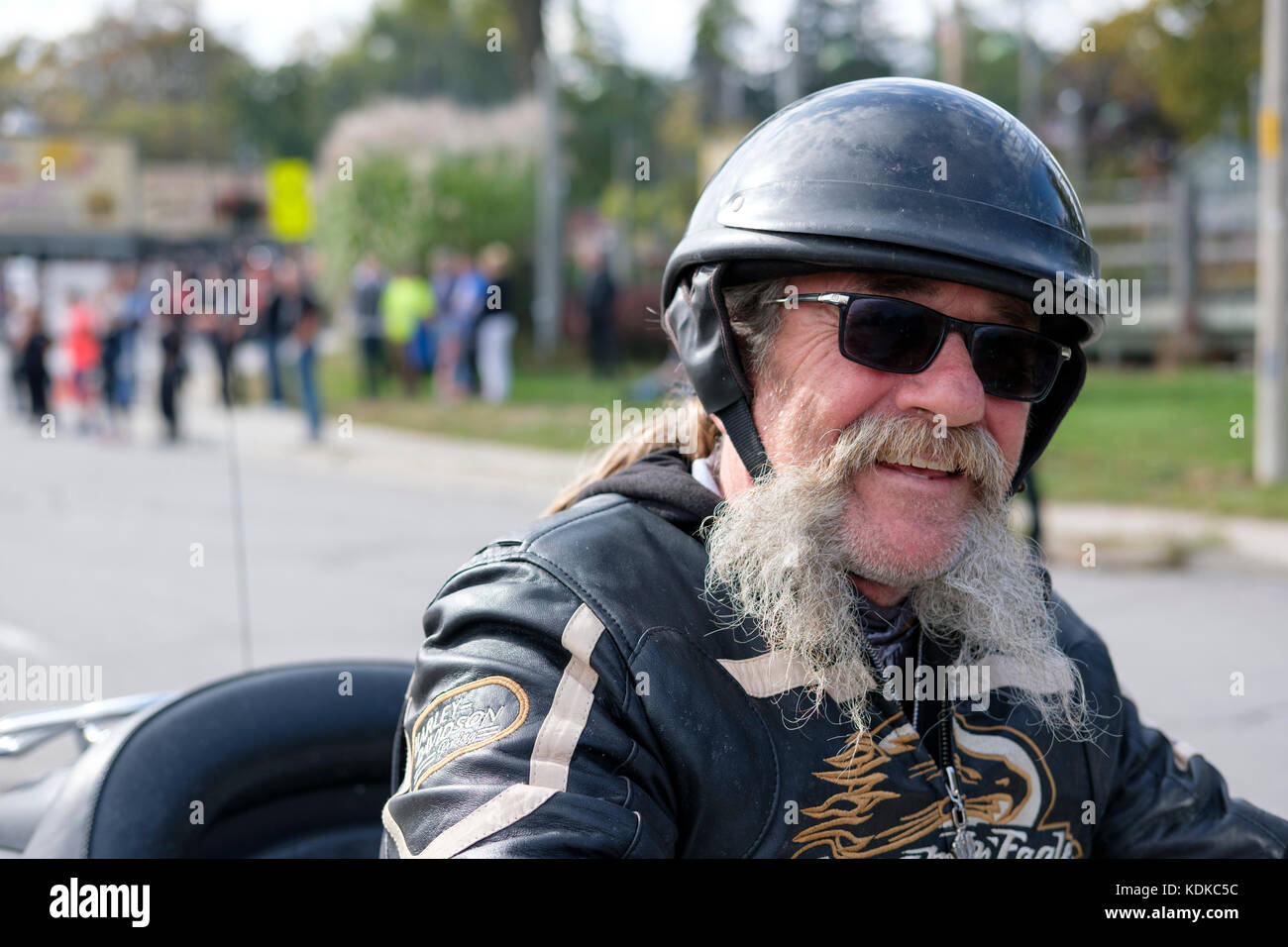 Port Dover, Ontario, Canada, le 13 octobre 2017. Des milliers de motocyclistes de partout au Canada et aux États-Unis se réunissent pour le vendredi 13 Motorcycle Rally, organisé tous les vendredi le 13 à Port Dover, Ontario, Canada, depuis 1981. L'événement est l'un des plus grands jours événements moto dans le monde. Le temps doux a contribué pour un grand nombre de cyclistes et de spectateurs, avec des centaines de motos personnalisées, des fournisseurs, de la musique live et des gens intéressants à regarder. Les hommes d'âge moyen biker avec barbe grise portant un casque, lunettes, souriant à la caméra. Credit : Rubens Alarcon/Alamy Live News Banque D'Images