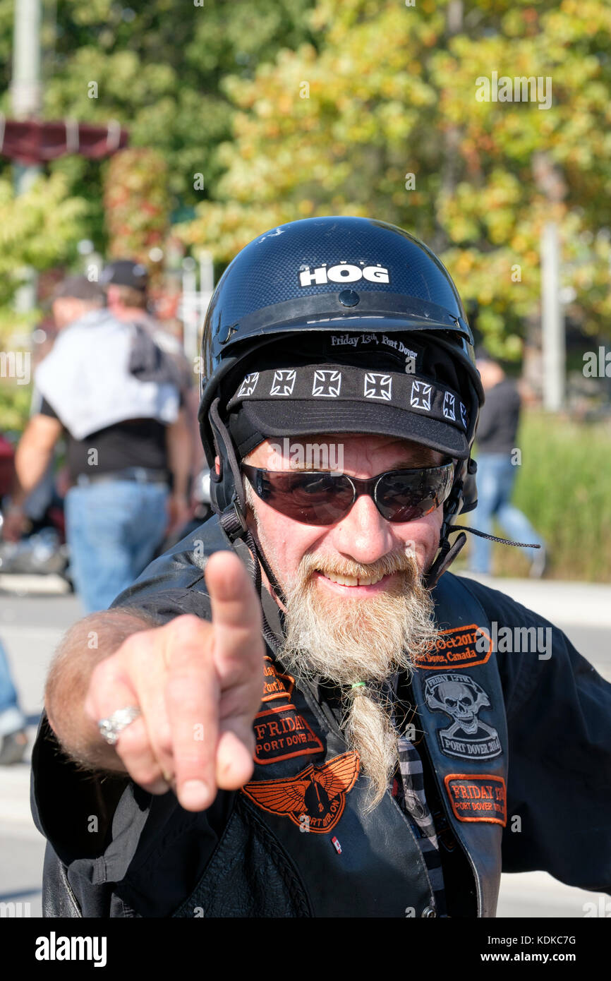 Port Dover, Ontario, Canada, le 13 octobre 2017. Des milliers de motocyclistes de partout au Canada et aux États-Unis se réunissent pour le vendredi 13 Motorcycle Rally, organisé tous les vendredi le 13 à Port Dover, Ontario, Canada, depuis 1981. L'événement est l'un des plus grands jours événements moto dans le monde. Cette année, la douceur du climat a contribué à un grand nombre de cyclistes et de spectateurs, avec des centaines de motos personnalisées, des fournisseurs, de la musique live et des gens intéressants à regarder. Biker barbu gris d'âge moyen et souriant face à la caméra. Credit : Rubens Alarcon/Alamy Live News Banque D'Images