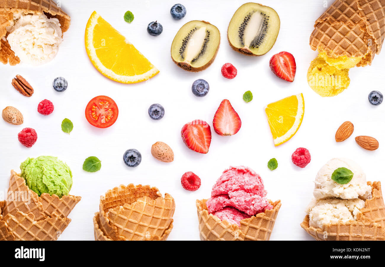 La crème glacée coloré avec les cônes et divers fruits bleuets Fraises Framboises ,,et feuilles de menthe poivrée setup sur fond blanc télévision lay et copier s Banque D'Images